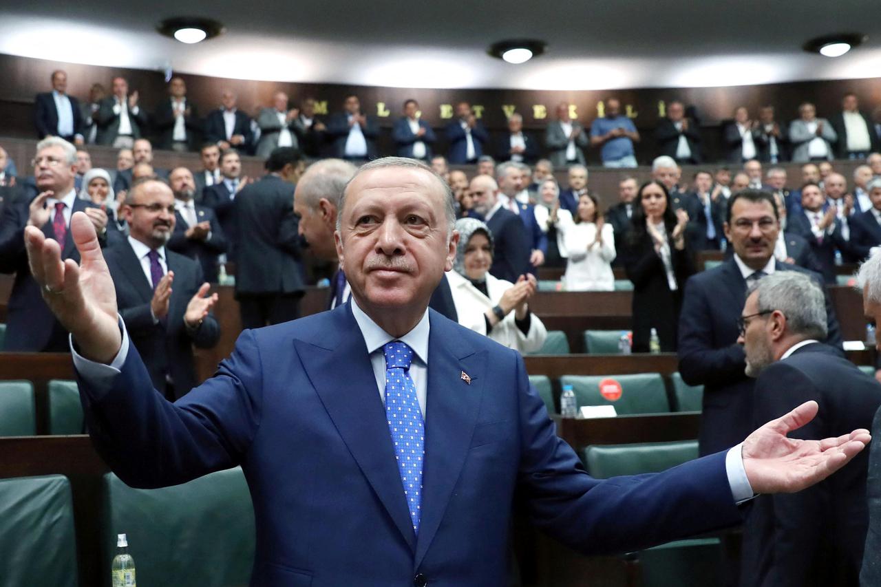 Turkish President Erdogan greets members of AKP during a meeting at the parliament in Ankara