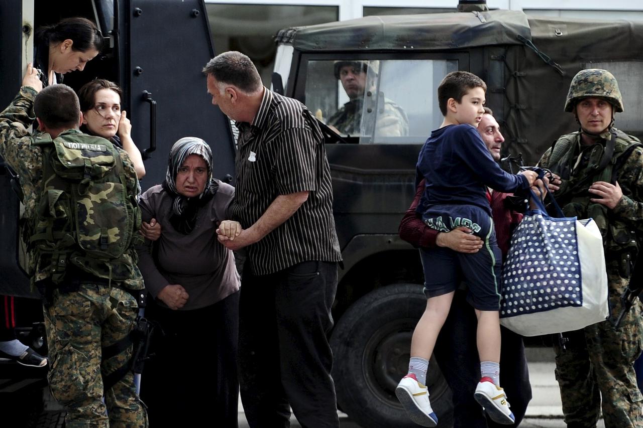 People are evacuated with an armored vehicle near a police checkpoint in Kumanovo, Macedonia, May 9, 2015. Explosions and heavy gunfire rocked the town in northern on Saturday as police moved against what authorities described as an 
