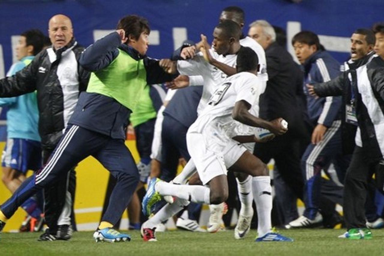 'Players and team members of Qatar\'s Al-Sadd (white) struggle with players and team members of South Korea\'s Suwon Samsung Bluewings (blue) during their AFC Champions League semifinal match at Suwon