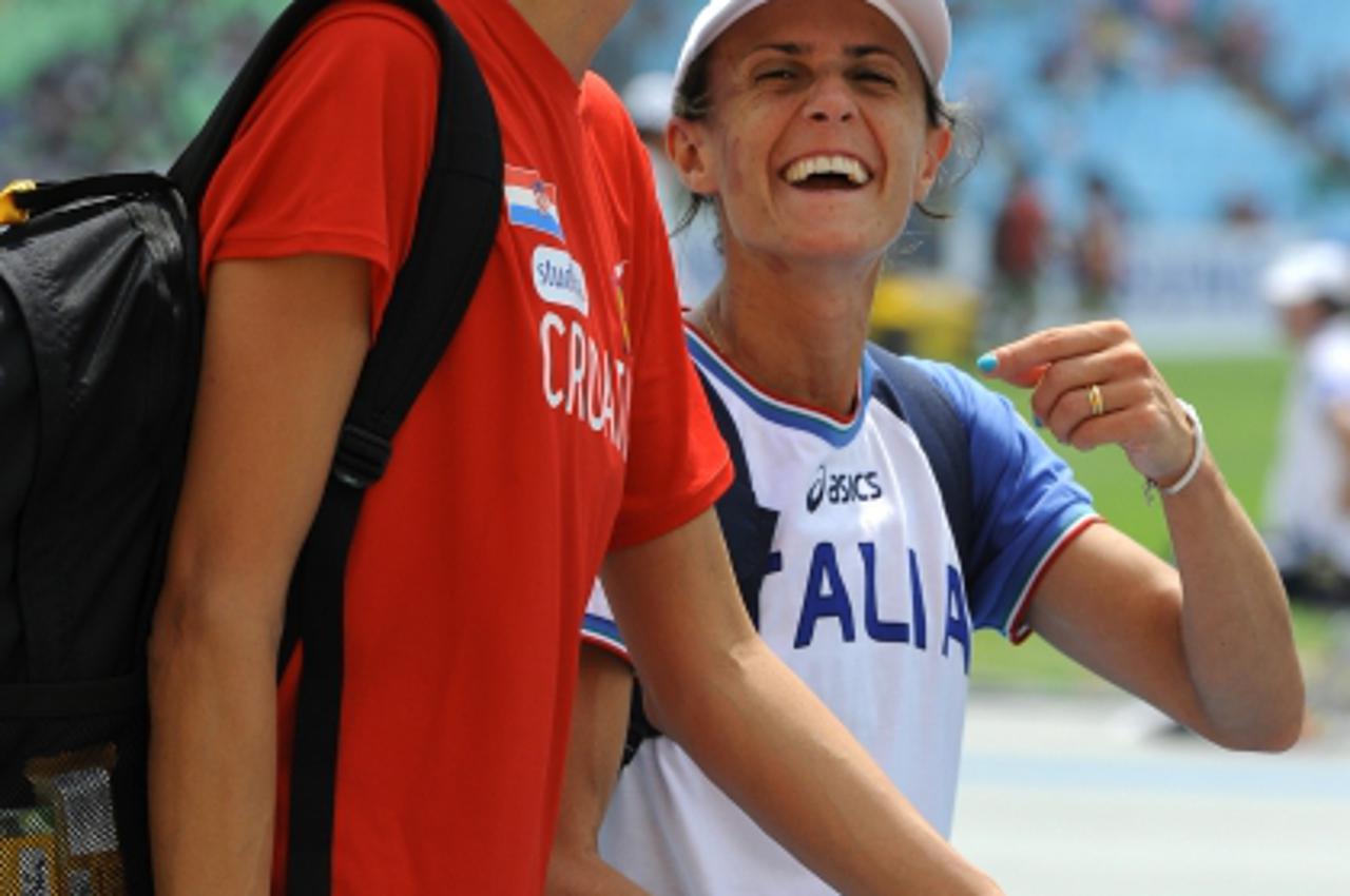 'Croatia\'s Blanka Vlasic (L) and Italy\'s Antonietta Di Martino (R) leave the track after competing in the women\'s high jump qualification round at the International Association of Athletics Federat