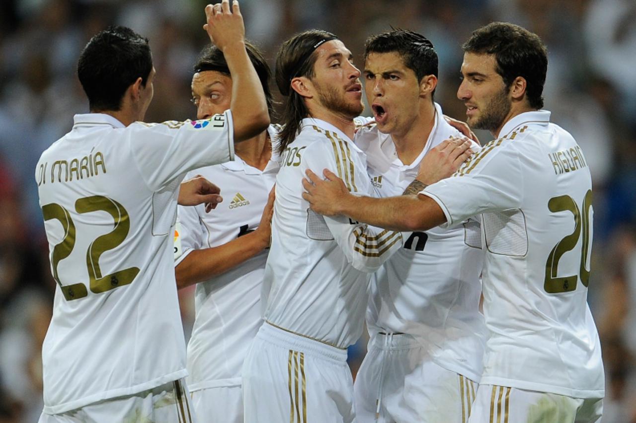 'Real Madrid\'s Portuguese forward Cristiano Ronaldo (2 R) celebrates his goal with teammates during the Spanish league football match Real Madrid vs Rayo Vallecano on September 24, 2011, at the Santi