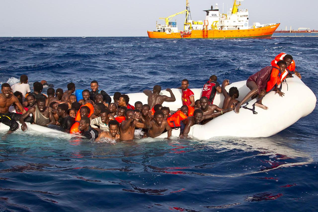 Migrants sit in a rubber dinghy during a rescue operation by SOS Mediterranee ship Aquarius off the coast of the Italian island of Lampedusa in this handout received April 18, 2016. SOS Mediterranee/Handout via REUTERS     ATTENTION EDITORS - THIS IMAGE W
