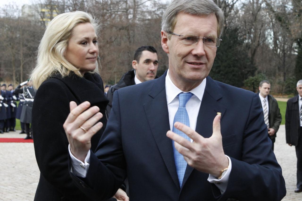 'German President Christian Wulff (R) gestures as he talk with his wife Bettina to students during the visit of Montenegro's President Filip Vujanovic at Bellevue presidential palace in Berlin, Dezem