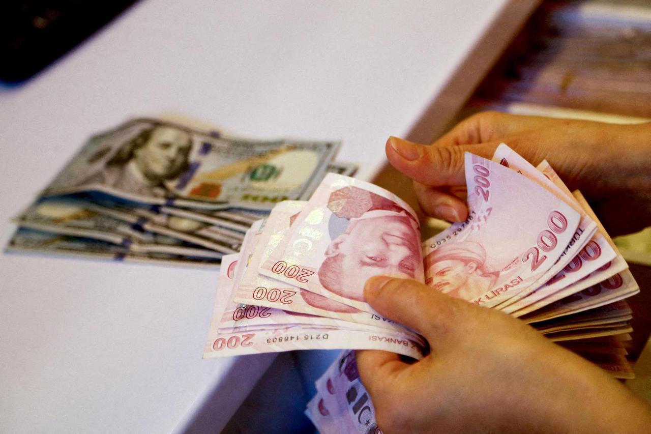 FILE PHOTO: A money changer counts Turkish lira banknotes at a currency exchange office in Ankara