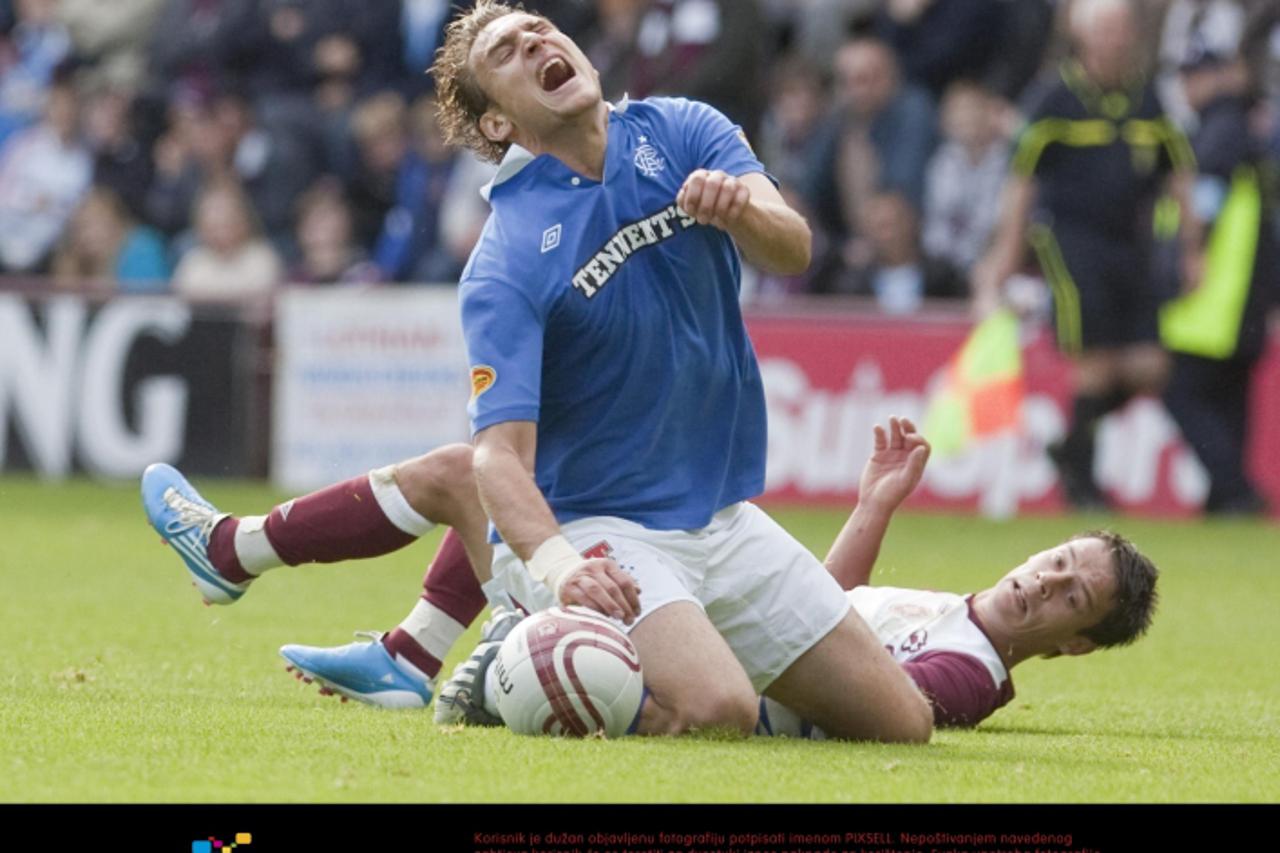 \'Rangers Nikica Jelavic is tackled by Heart of Midlothian midfielder Ian Black during the Clydesdale Bank Scottish Premier League match at Tynecastle, Edinburgh. Photo: Press Association/Pixsell\'