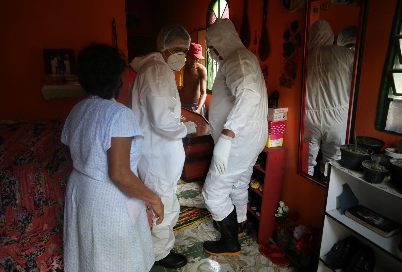 Outbreak of the coronavirus disease (COVID-19), in Manaus Workers of the SOS Funeral, wearing protective clothing, carry the coffin of a woman who died from the coronavirus disease (COVID-19), from her house, in Manaus, Brazil, May 29, 2020. REUTERS/Bruno Kelly BRUNO KELLY