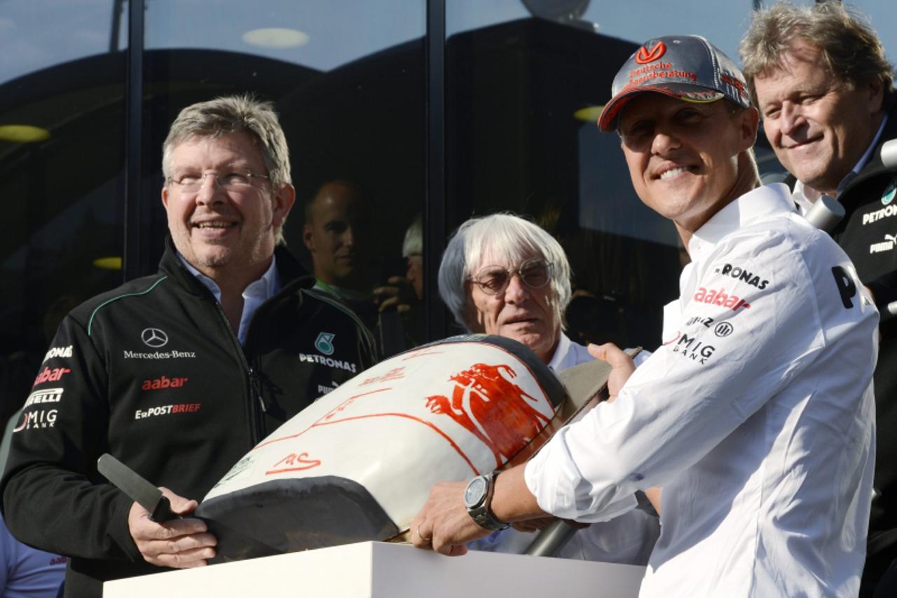 'Mercedes Formula One driver Michael Schumacher of Germany stands with Mercedes Formula One team principal Ross Brawn (L) and Formula One Commercial Supremo Bernie Ecclestone (C) as he celebrates his 