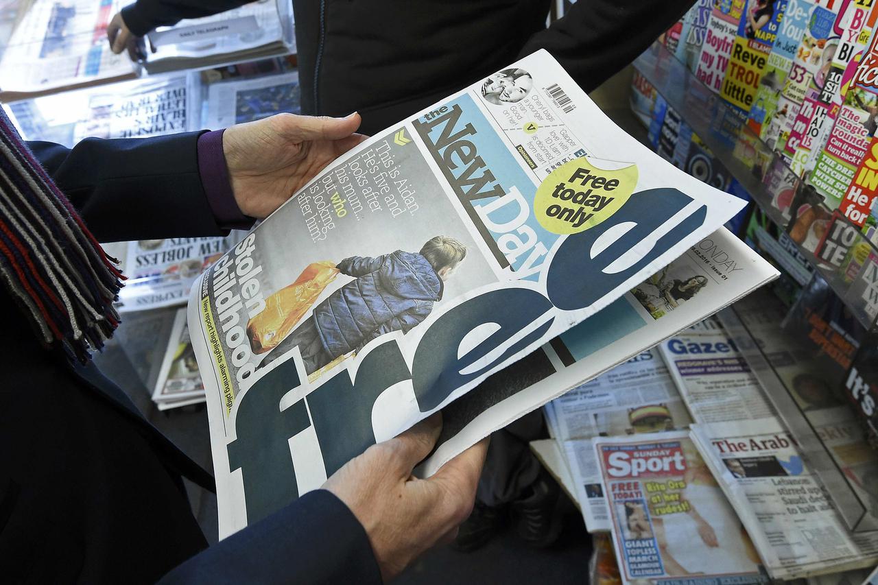 A customer holds a copy of the New Day at a newsagents in central London, Britain February 29, 2016. The new national newspaper launched on Monday. REUTERS/Toby Melville