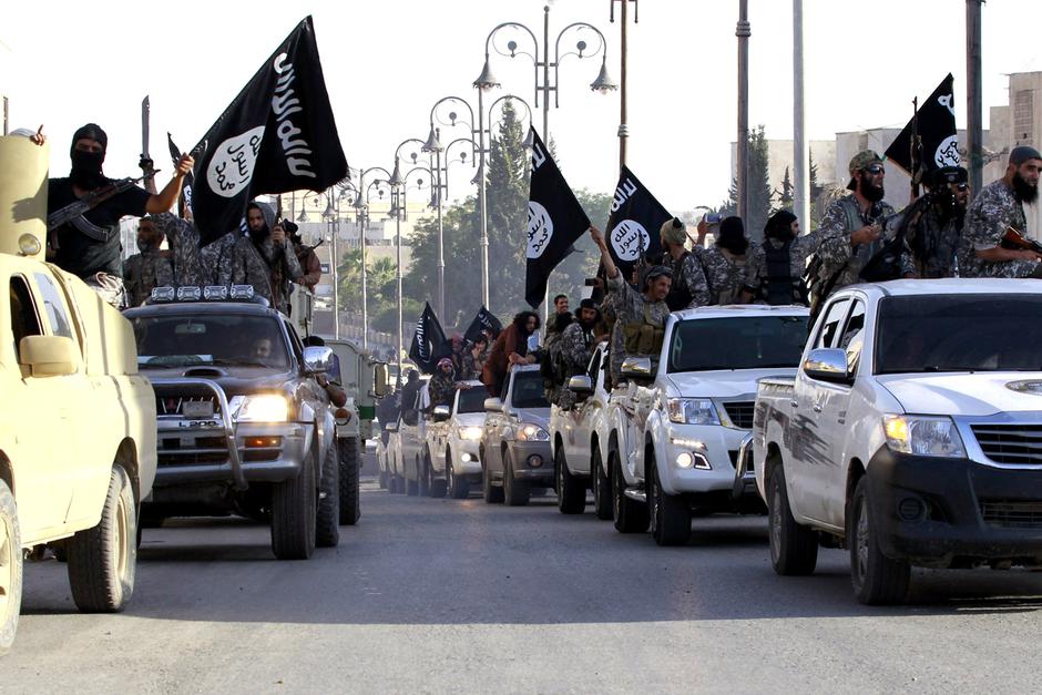 Militant Islamist fighters parade on military vehicles along the streets of northern Raqqa province June 30, 2014. Militant Islamist fighters held a parade in Syria's northern Raqqa province to celebrate their declaration of an Islamic 