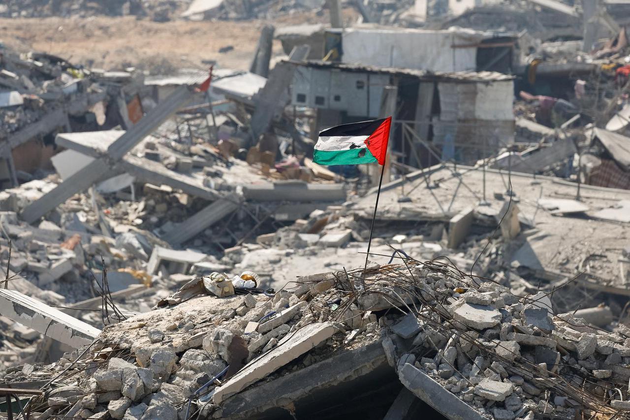 A damaged Palestinian flag flutters over the rubble of destroyed buildings, amid a ceasefire between Israel and Hamas, in Gaza City