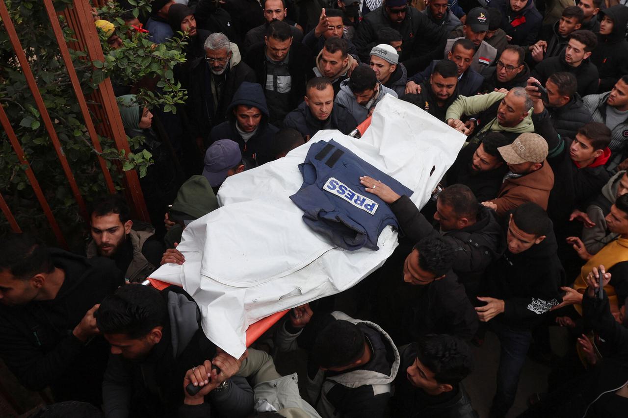 Mourners carry the body of one of the Palestinian journalists killed in an Israeli airstrike, in Khan Younis