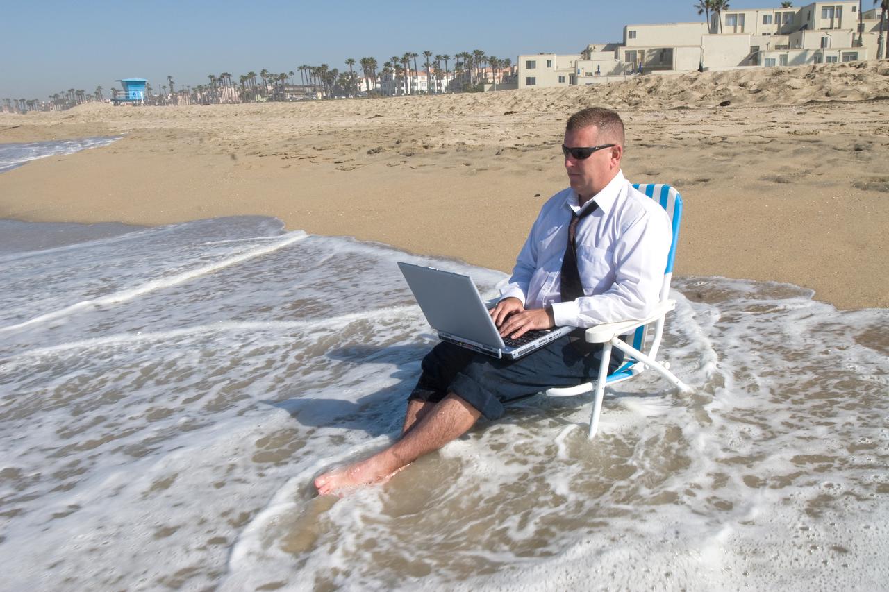 A businessman takes his office to the beach.