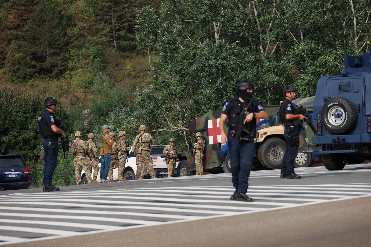 Police officers patrol in the aftermath of a shooting, on the road to Banjska village