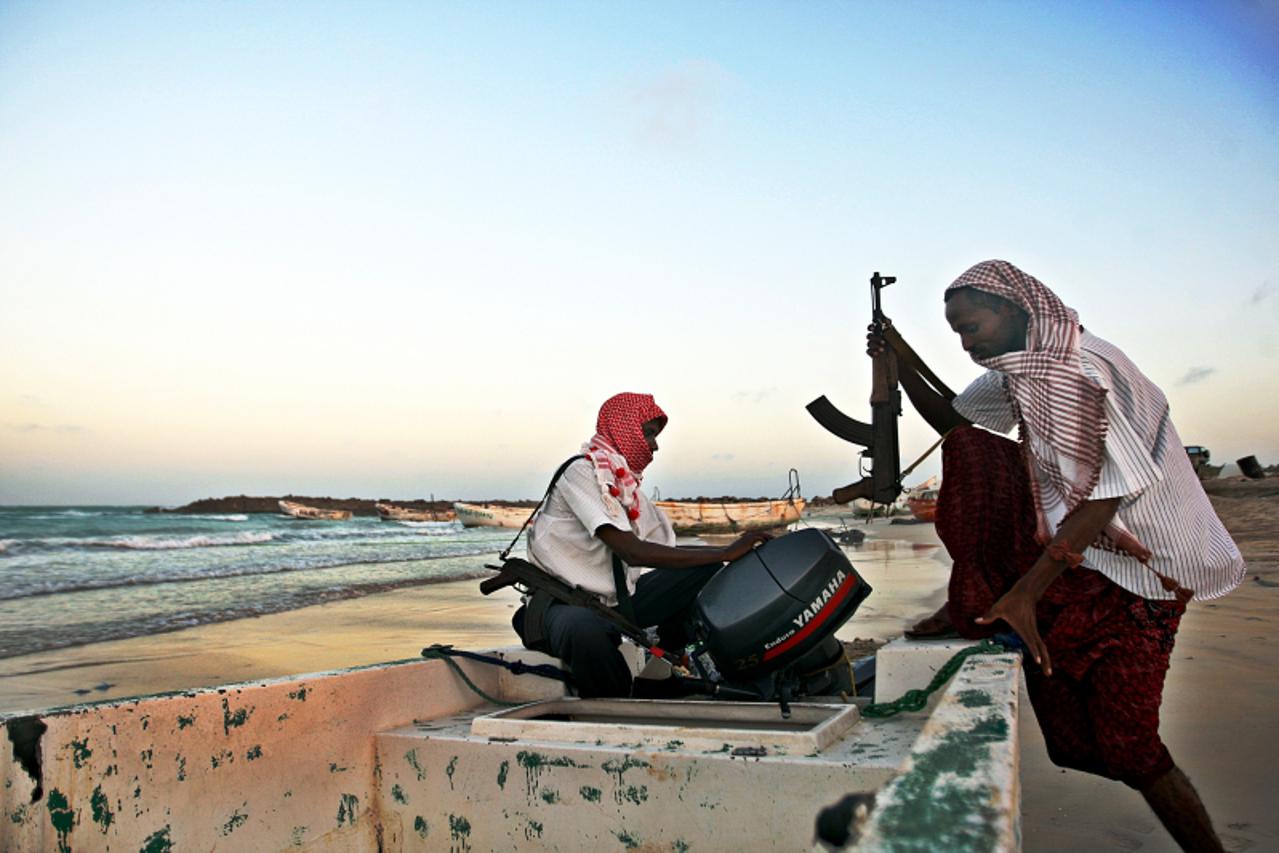 \'Photo taken on January 4, 2010 shows armed Somali pirates carrying out preparations to a skiff in Hobyo, northeastern Somalia, ahead of new attacks on ships sailing in the Gulf of Aden. Greek cargo 