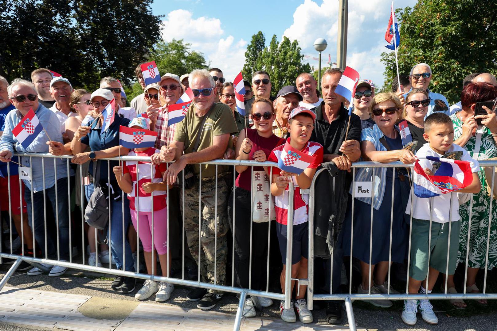U zraku se osjeća ponos, a u mnoštvu su i obitelji koje su stigle iz inozemstva, prilagodivši svoje godišnje odmore ovom povijesnom trenutku. Ova je svečanost treći vojni mimohod otkako je Hrvatska stekla neovisnost, a ujedno i dosad najsnažniji prikaz vojne moći.