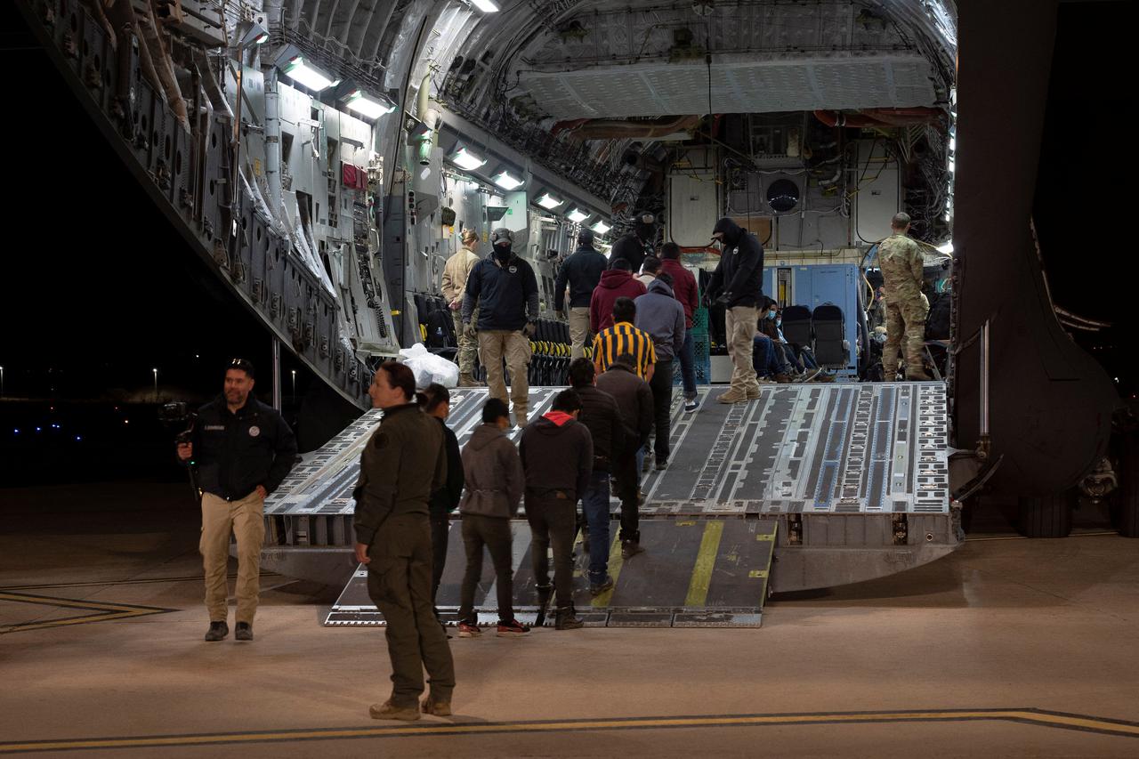 Customs and Border Protection agents load detained migrants onto a C-17 Globemaster III for a removal flight in Tucson