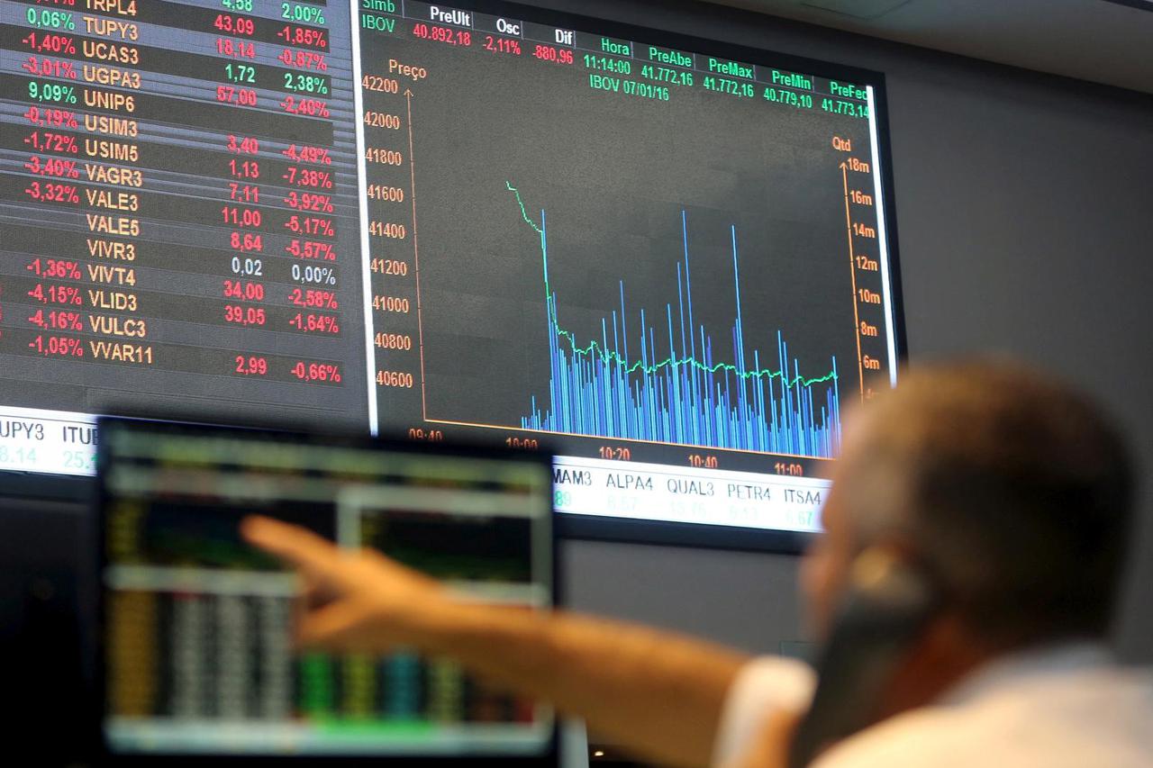 FILE PHOTO: A man points to electronic board showing fluctuations of market indices at the floor of Brazil's BM&F Bovespa Stock Market in Sao Paulo