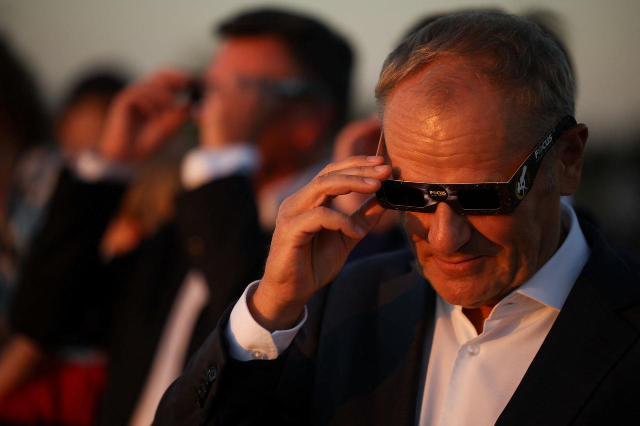 Polish Prime Minister Donald Tusk takes off special protective glasses during partial solar eclipse, at the Copernicus Science Centre in Warsaw,