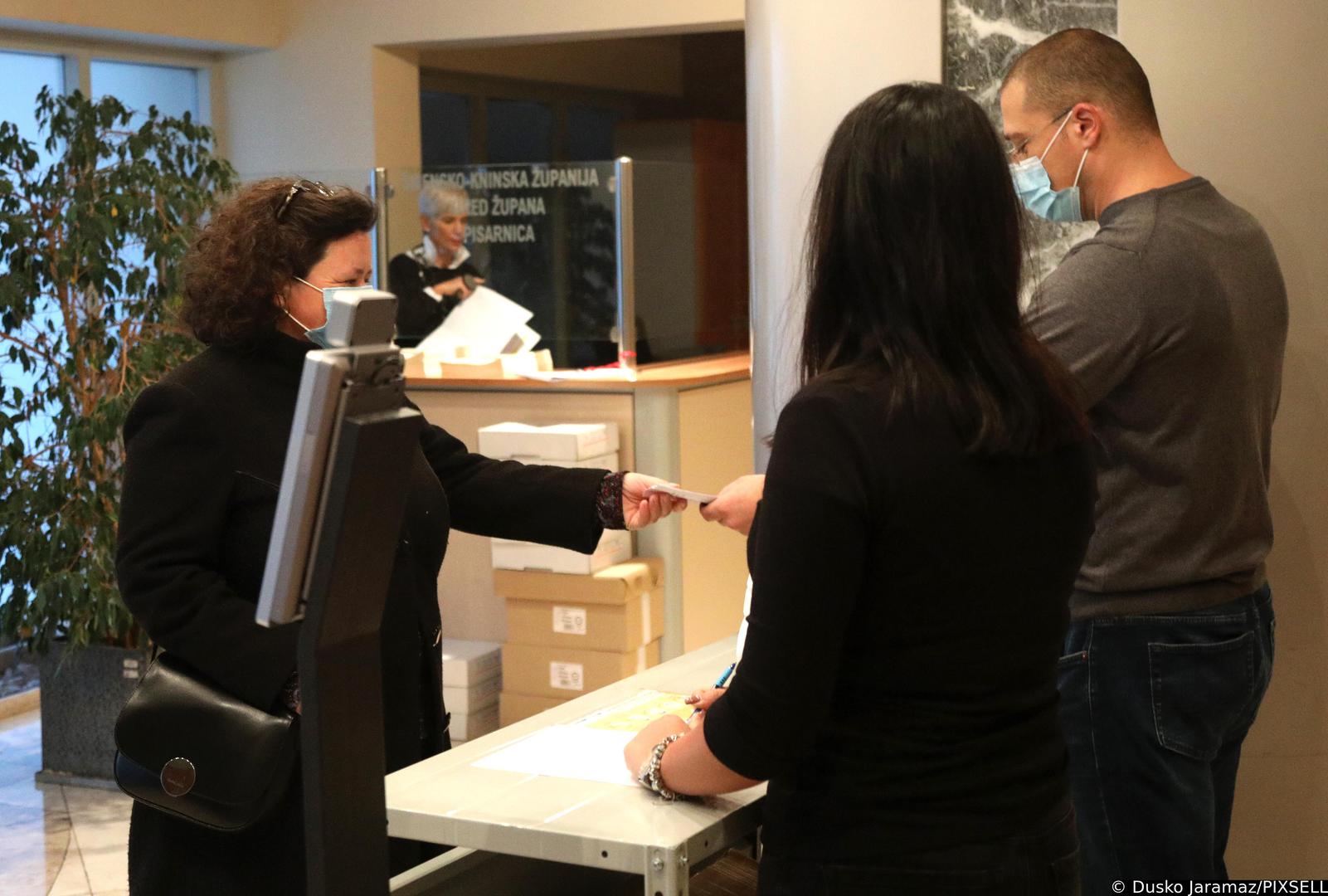 16.11.2021., Sibenik - Prvi je dan obvezne primjene covid potvrda koje dokazuju da je netko cijepljen, da je prebolio covid-19 ili je negativan i od danas postaju obvezne za ulaz u javne i drzavne ustanove. Provjera djelatnika zupanijske uprave i cekanje ispred Fine.  