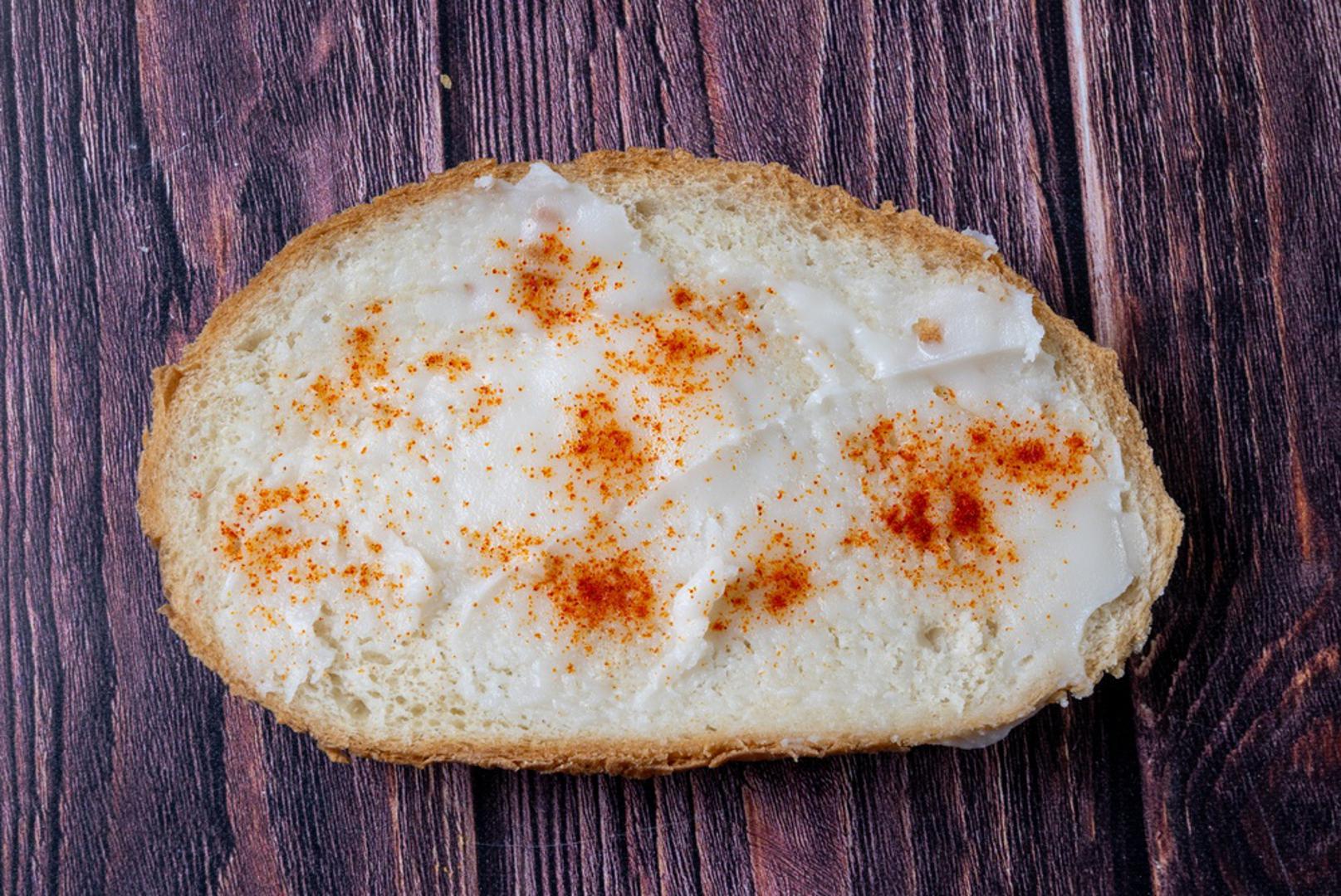 Kruh, mast i crvena paprika: Kriška kruha namazana svinjskom mašću i posuta crvenom paprikom za mnoge je bila sasvim normalna užina. Jela se nakon škole, kod bake ili usput, dok se trčalo natrag na ulicu. Danas bi se zbog količine masnoće i soli vjerojatno preporučivala umjerenost, ali tada je to bio klasik koji se nije dovodio u pitanje.