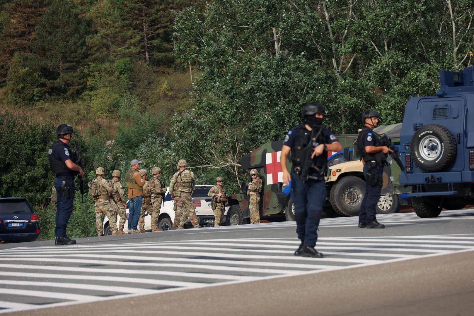 People work as Kosovo police and U.S. and EU troops stand by after one police officer was killed, another hurt in Kosovo gunfire, in Josevik, Kosovo September 24, 2023. REUTERS/Fatos Bytyci Photo: FATOS BYTYCI/REUTERS