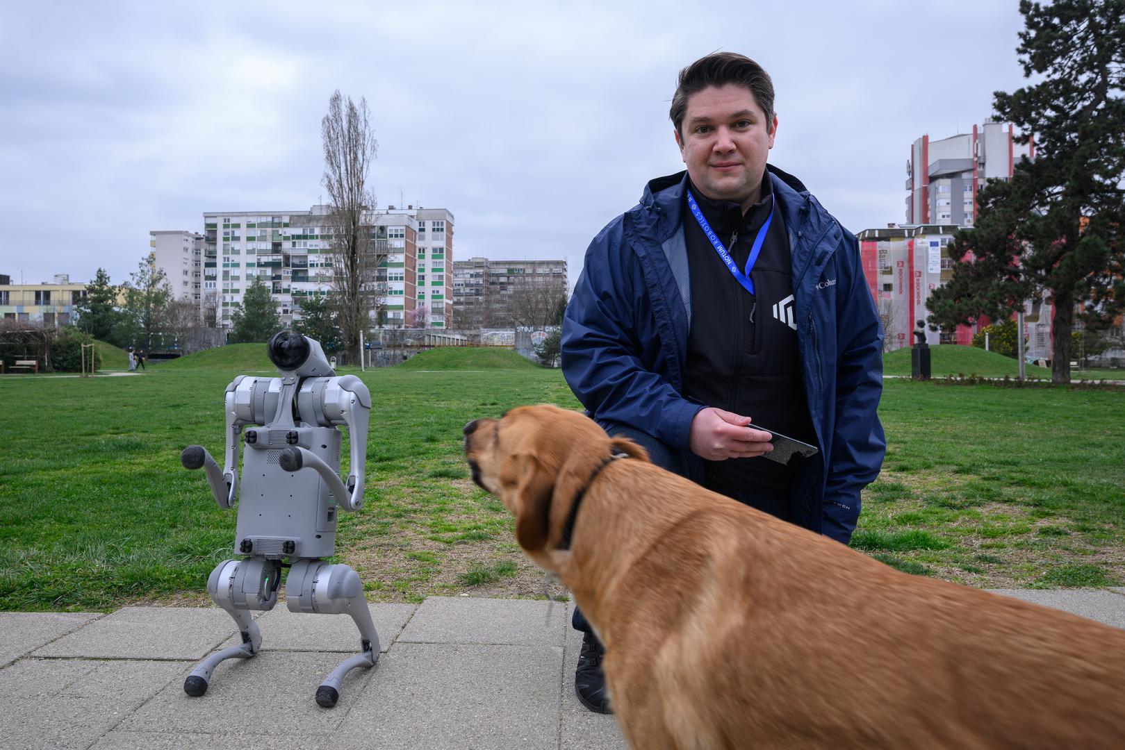 07.03.2024., Velika Gorica -  Milan Rajcevic, vlasnik i direktor tvrtke Notum Robotics sa suradnikom Ivanom Batinicem prosetao je Parkom dr. Franje Tudjmana u velikoj Gorici u drustvu robota psa. Za robota su podjednako bili zainteresirani prolaznici i njihovi ljubimci psi. Robot pas je komercijalni proizvod koji se radi po narudjbi, a ono sto je kod njega interesantno i unikatno su softverska rijesenja. Poanta je da ta platforma bude autonomna, bez ljudske intervencije i sa minimalnim odrzavanjem izvrsava zadatke prema svojem programu, da se snalazi u nepoznatim okolnostima, po nepoznatom terenu. Primjene su neogranicene, od sigurnosnih primjena, sluzbe spasavanja, nadzora te interakcije i edukacije. Puni se do 24 sata zbog tehnologije baterije i moze raditi do 3 sata, a trcati moze brzinom do 20 km/h. Trenutno nije vodootporan ali s vremenom moze postati i vodootporan i vatrootporan za siri spektar primjena. Milan Rajcevic.
 Photo: Davor Puklavec/PIXSELL