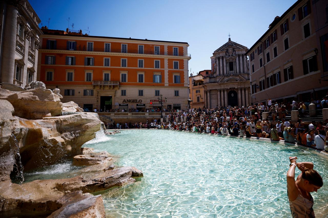 FILE PHOTO: Tourists cool off at Trevi Fountain as a heat wave hits Rome