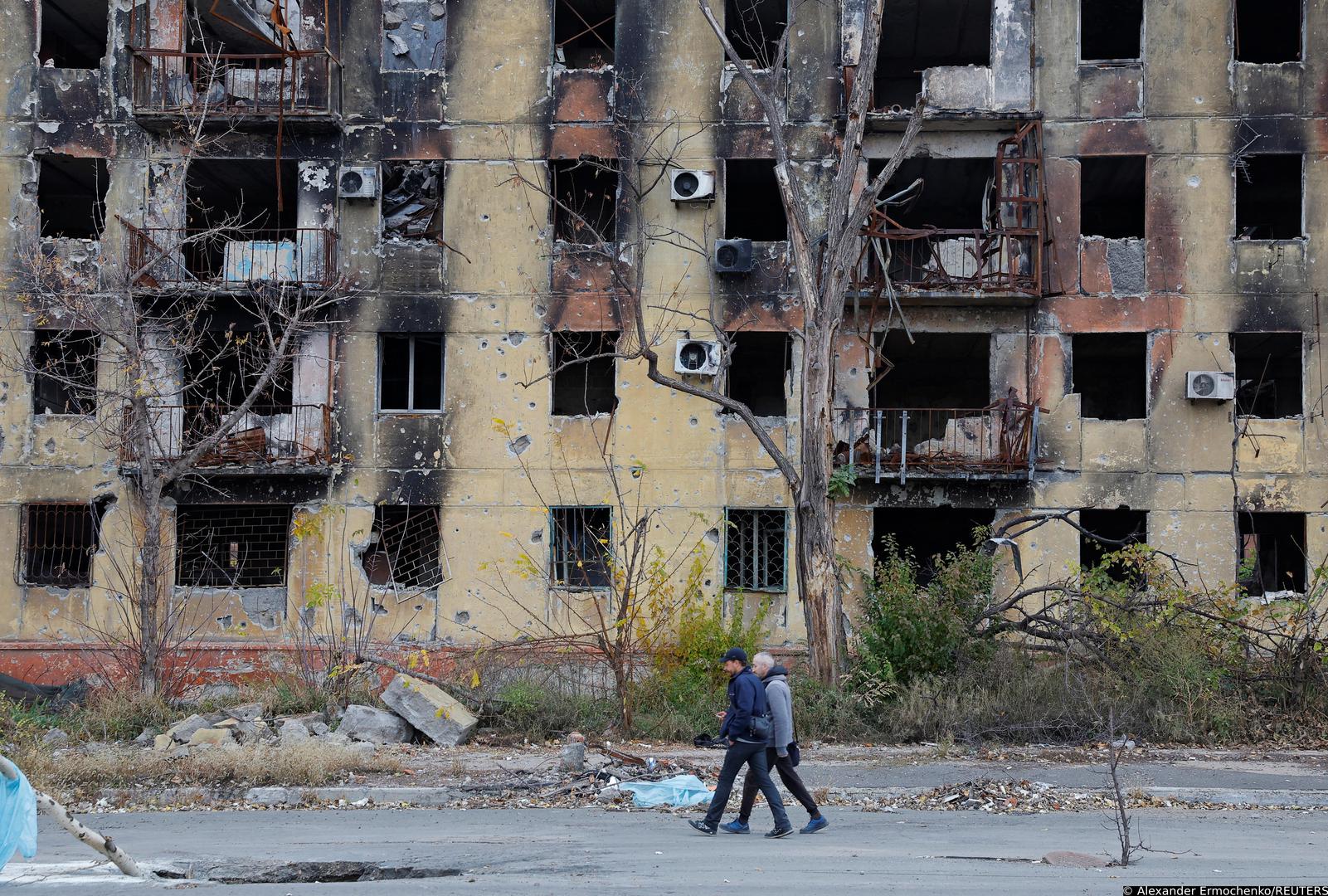 People walk past a building damaged in the course of Russia-Ukraine conflict in Mariupol, Russian-controlled Ukraine, November 9, 2022. REUTERS/Alexander Ermochenko Photo: Alexander Ermochenko/REUTERS