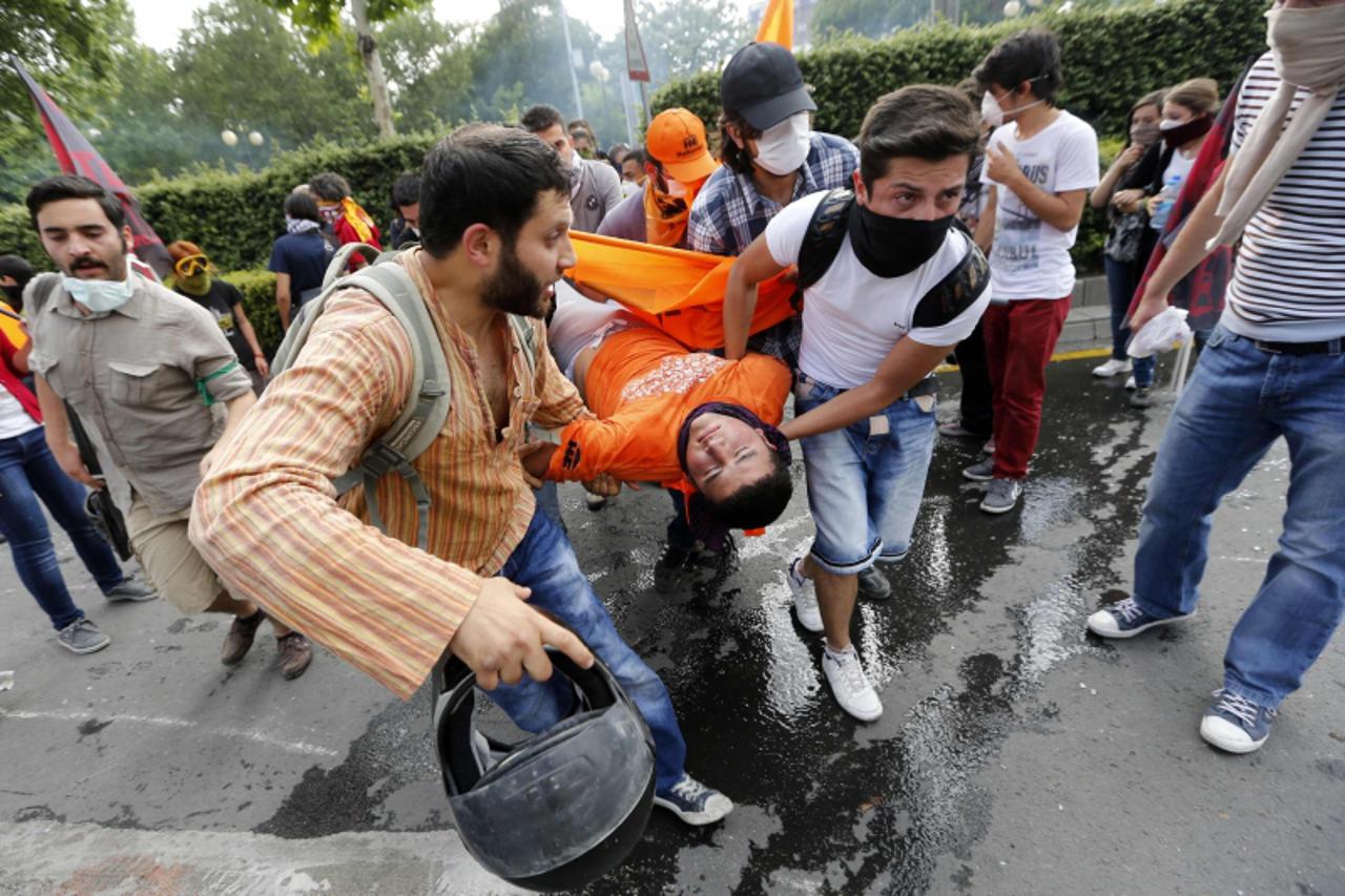 'Demonstrators carry an injured man during a protest against Turkey's Prime Minister Tayyip Erdogan and his ruling AK Party in central Ankara June 2, 2013. Erdogan accused Turkey's main secular oppo