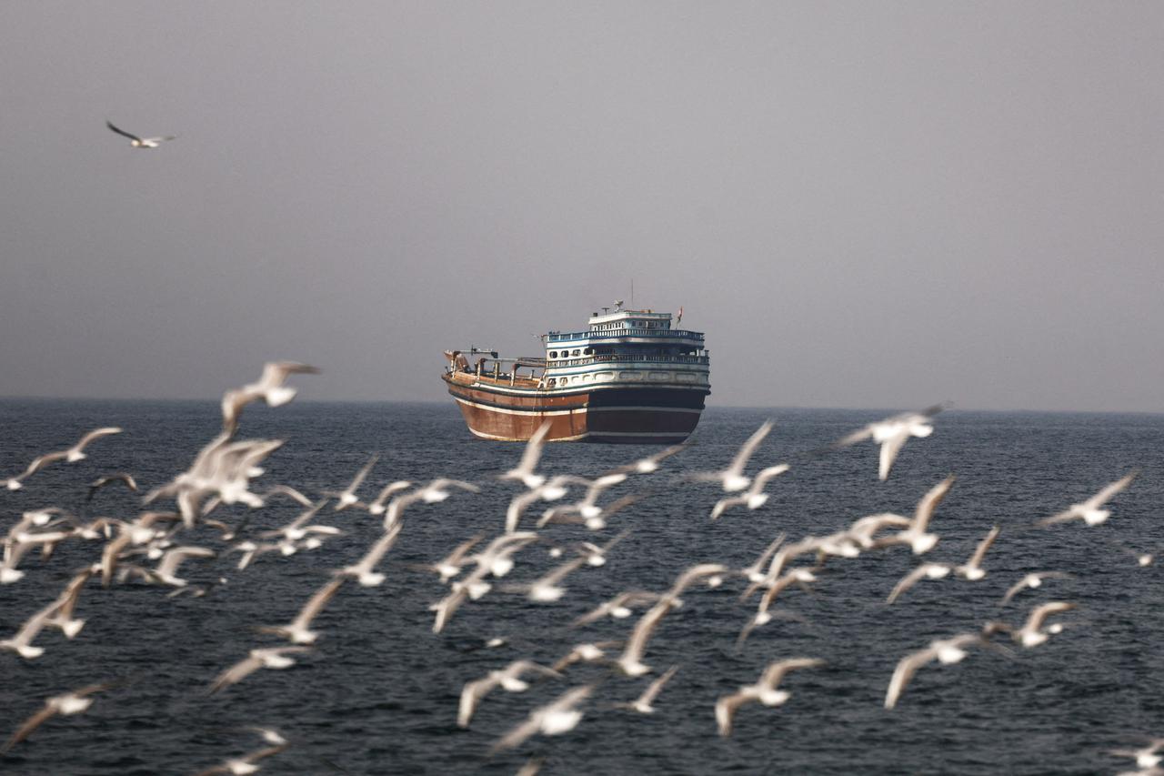 Birds fly near the boat in the Strait of Hormuz amid the U.S.-Israeli conflict with Iran, as seen from Musandam