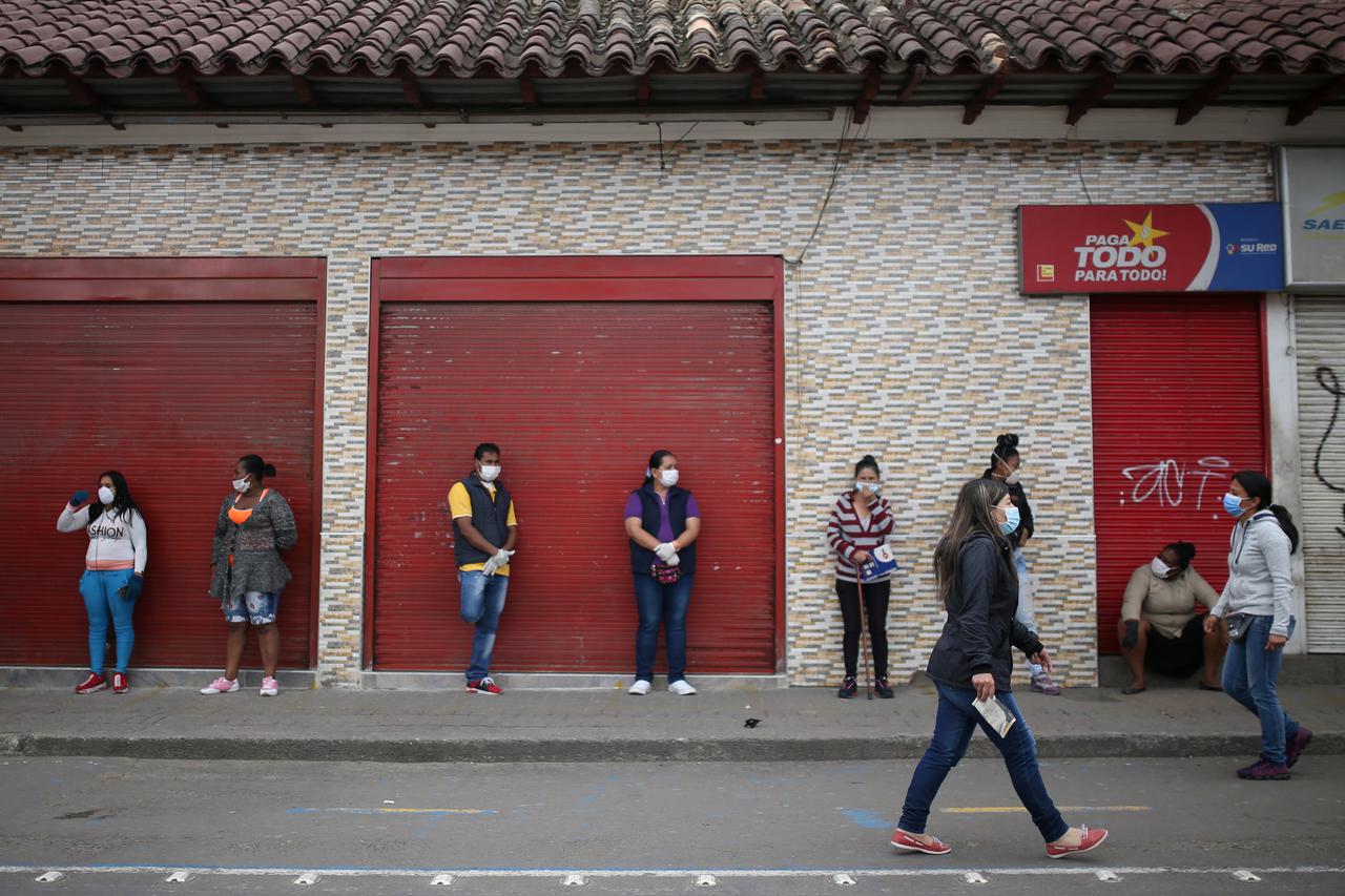 People wear face masks while queuing to enter a supermarket during the mandatory isolation decreed by the Colombian government as a preventive measure against the spread of the coronavirus disease (COVID-19) in Soacha