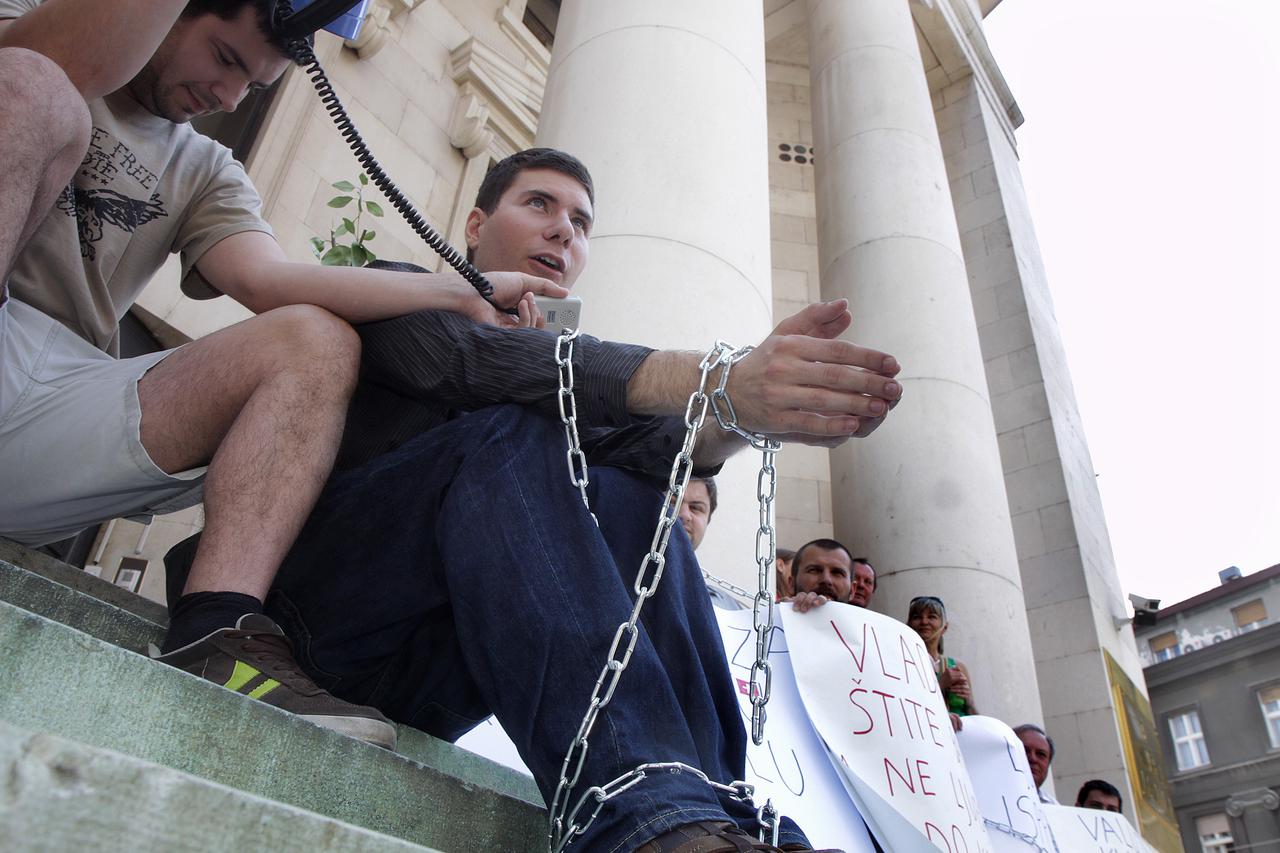 12.06.2011., Zagreb - Na Trgu hrvatskih velikana, ispred zgrade Narodne banke, odrzan je prosvjed protiv banaka u Hrvatskoj. Na prosvjedu je sudjelovao i Ivan Pernar koji se za tu prigodu vezao lanciima . Photo: Zarko Basic/PIXSELL