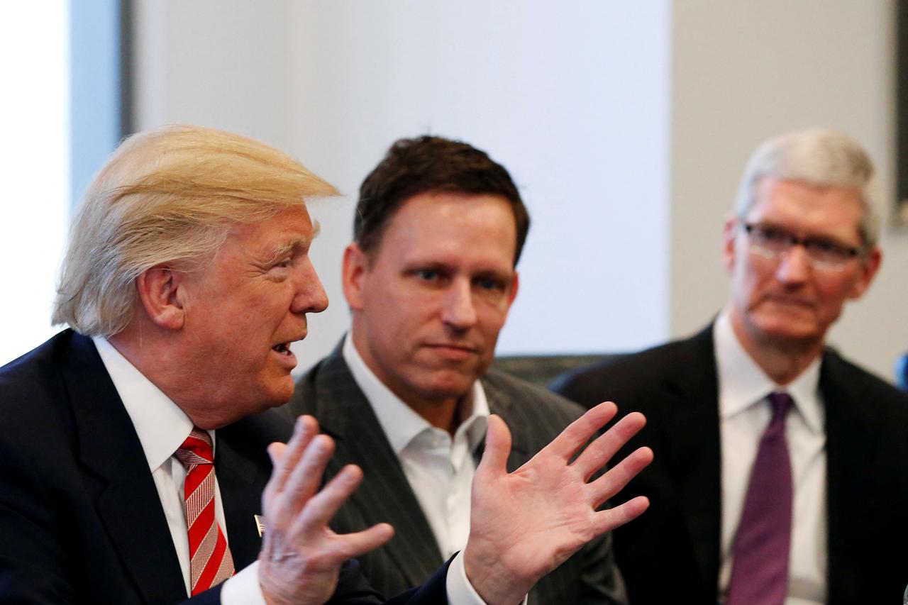 FILE PHOTO: U.S. President-elect Donald Trump speaks as PayPal co-founder and Facebook board member Peter Thiel and Apple Inc CEO Tim Cook look on during a meeting with technology leaders at Trump Tower in New York
