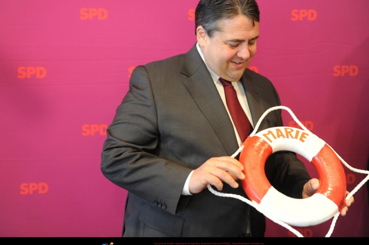 'SPD chairman Sigmar Gabriel holds a lifebuoy lettered with the name of his new-born daughter Marie prior to the federal board meeting of the German party Social Democrats SPD in Kiel, Germany, 23 Apr