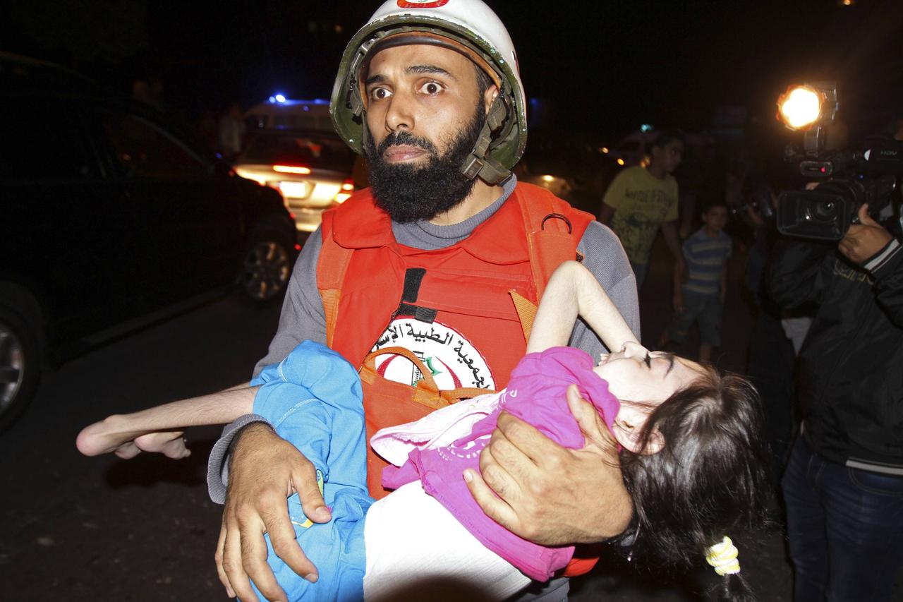 A member of a Lebanese medical organisation carries a girl who had fled from clashes between Islamic militants and Lebanese Army forces during a ceasefire in three neighbourhoods, in the Bab al-Tabbaneh neighbourhood of Tripoli October 26, 2014.  Lebanese