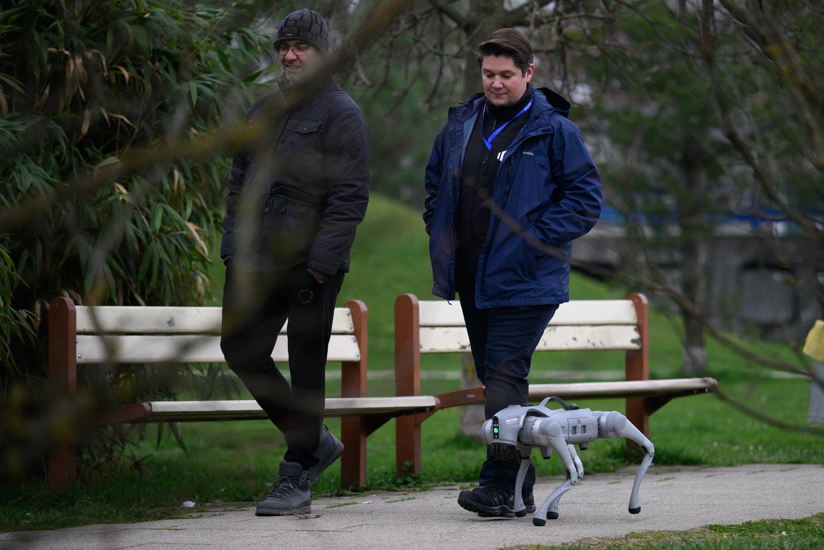 07.03.2024., Velika Gorica -  Milan Rajcevic, vlasnik i direktor tvrtke Notum Robotics sa suradnikom Ivanom Batinicem prosetao je Parkom dr. Franje Tudjmana u velikoj Gorici u drustvu robota psa. Za robota su podjednako bili zainteresirani prolaznici i njihovi ljubimci psi. Robot pas je komercijalni proizvod koji se radi po narudjbi, a ono sto je kod njega interesantno i unikatno su softverska rijesenja. Poanta je da ta platforma bude autonomna, bez ljudske intervencije i sa minimalnim odrzavanjem izvrsava zadatke prema svojem programu, da se snalazi u nepoznatim okolnostima, po nepoznatom terenu. Primjene su neogranicene, od sigurnosnih primjena, sluzbe spasavanja, nadzora te interakcije i edukacije. Puni se do 24 sata zbog tehnologije baterije i moze raditi do 3 sata, a trcati moze brzinom do 20 km/h. Trenutno nije vodootporan ali s vremenom moze postati i vodootporan i vatrootporan za siri spektar primjena. Ivan Batinic, Milan Rajcevic.
 Photo: Davor Puklavec/PIXSELL