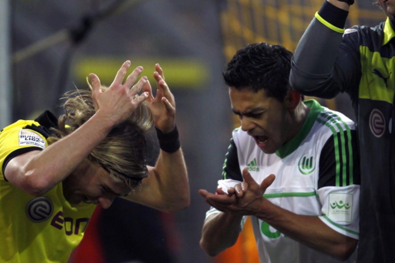 'Borussia Dortmund's Marcel Schmelzer (L) and Wolfsburg's Josue react during the German first division Bundesliga soccer match in Dortmund December 8, 2012. REUTERS/Ina Fassbender (GERMANY - Tags: S