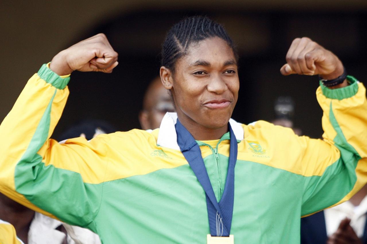 'Caster Semenya gestures to a crowd gathered to greet her at the OR Tambo International Airport in Johanneburg August 25 ,2009. Semenya, whose 800 metres victory at the World Championships in Athletic