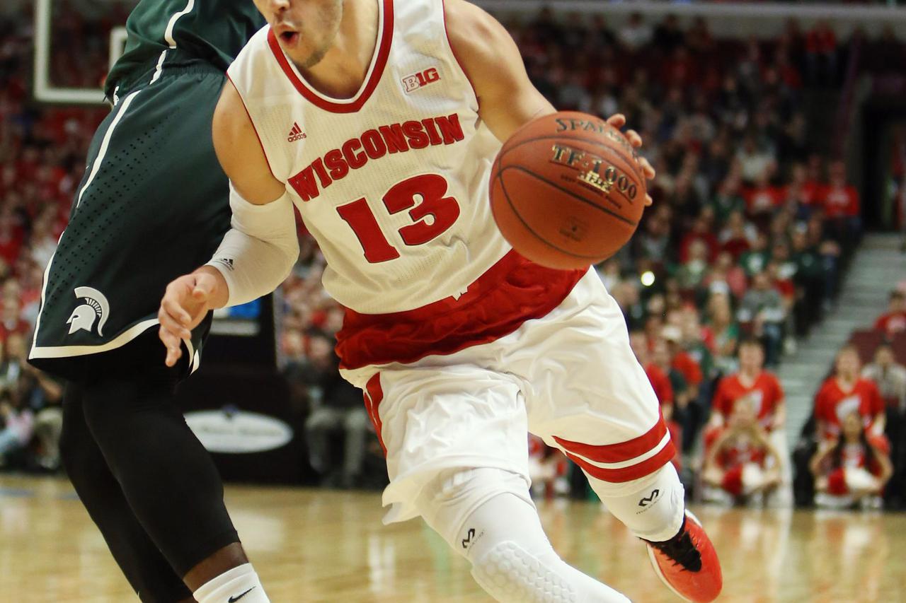 Mar 15, 2015; Chicago, IL, USA; Wisconsin Badgers forward Duje Dukan (13) gets around the defense of Michigan State Spartans guard/forward Branden Dawson (22)  during the first half in the championship game of the Big Ten Tournament at United Center. Mand