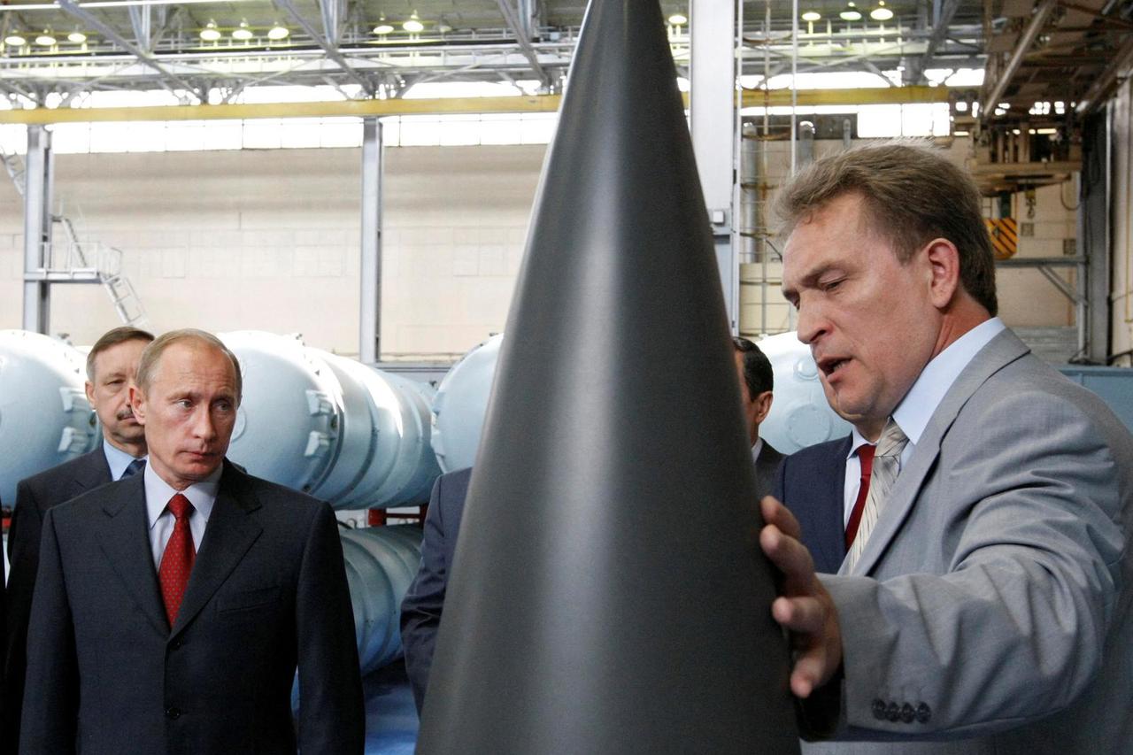 FILE PHOTO: Russian Prime Minister Putin listens to CEO of Almaz-Antey Air Defence firm, Menschikov, during tour of its plant in Moscow