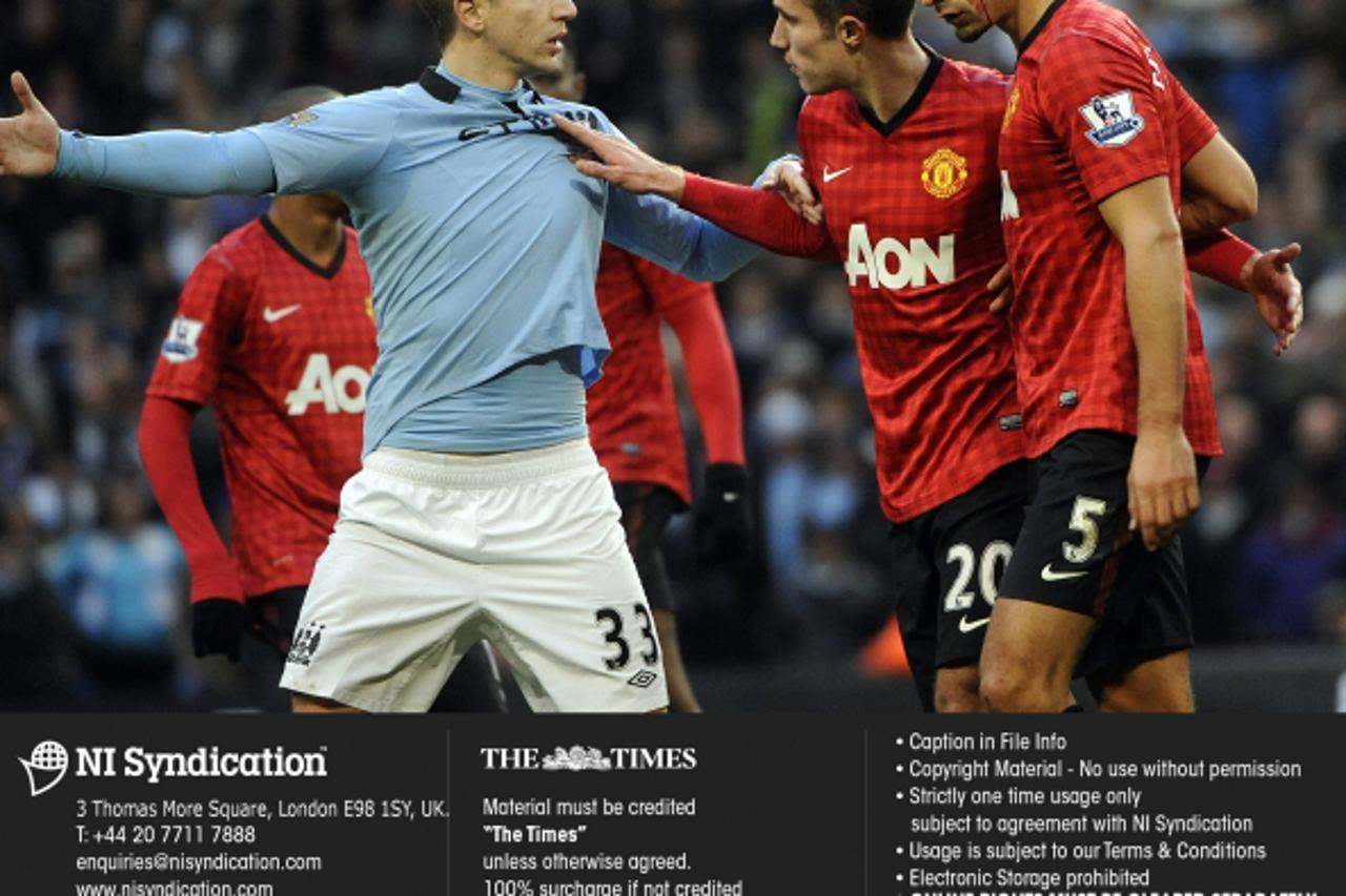 'Manchester City v Manchester United, Barclays Premier League. Rio Ferdinand with cut eye after being hit by a coin, with Robin Van Persie and City\'s Matija Nastasic. Credit: The Times. Online rights
