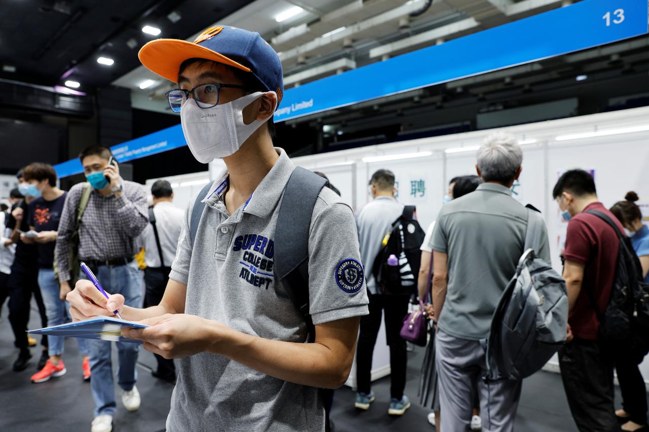 A job seeker wearing a face mask fills in forms at the Wan Chai Job Fair, following the coronavirus disease (COVID-19) outbreak, in Hong Kong