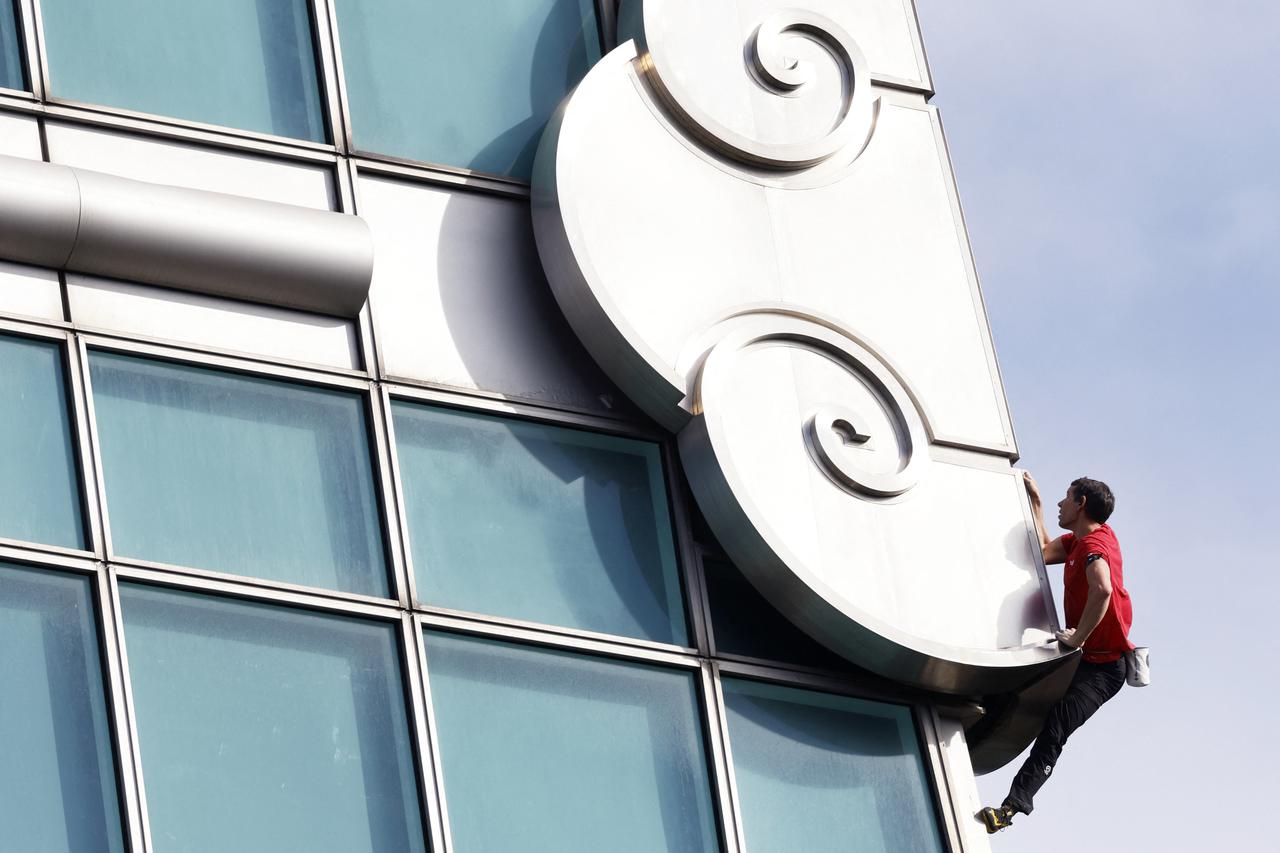 Climber Alex Honnold free soloing Taipei 101 Skyscraper