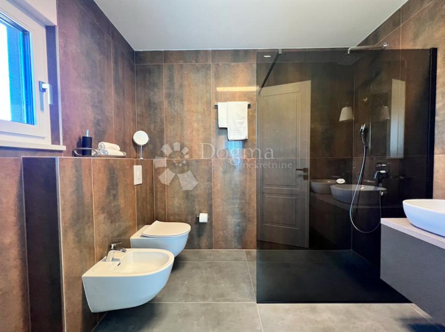  Kuća ima PVC stolariju u antracit boji, osiguran je video nadzor i alarmni sustav, a na raspolaganju su garaža i vanjsko parkirno mjesto.