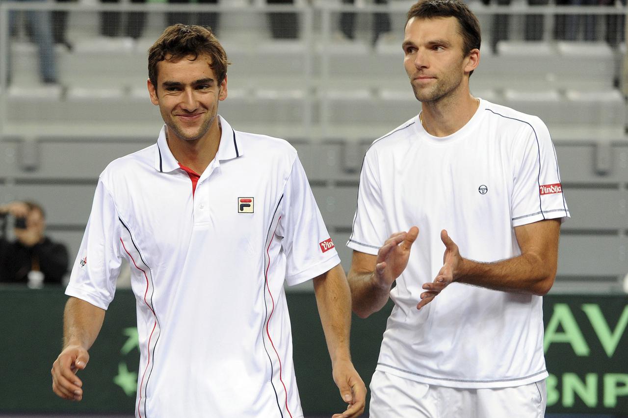 Marin Cilic (L) and Ivo Karlovic of Croatia celebrate their win over Giovanni Lapentti and Nicolas Lapentti of Ecuador during their Davis Cup doubles match in Croatia's northern town of Varazdin March 6, 2010.     REUTERS/Davor Kovacevic (CROATIA - Tags: 