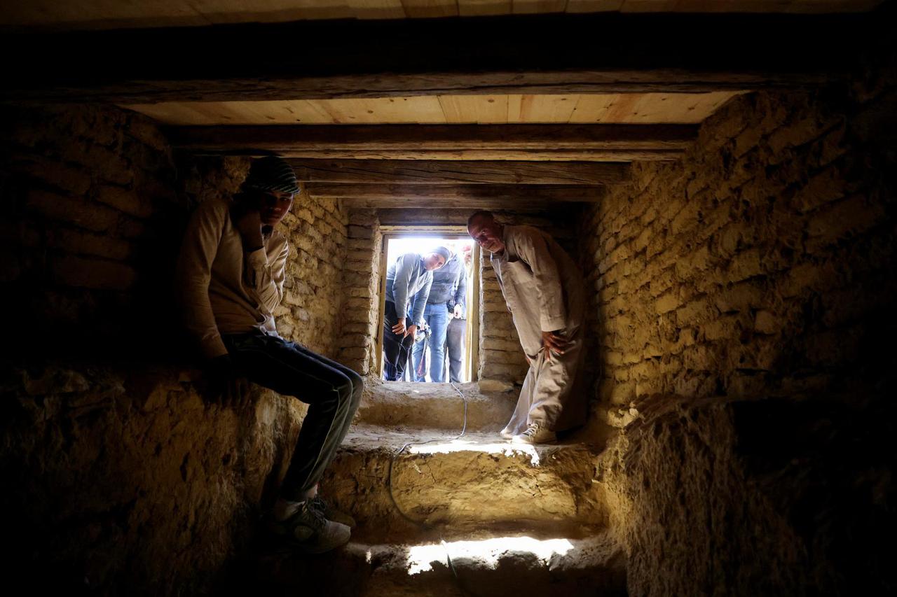 A man sits inside a tomb after the announcement of 4,300-year-old sealed tombs discovered in Egypt's Saqqara necropolis, in Giza