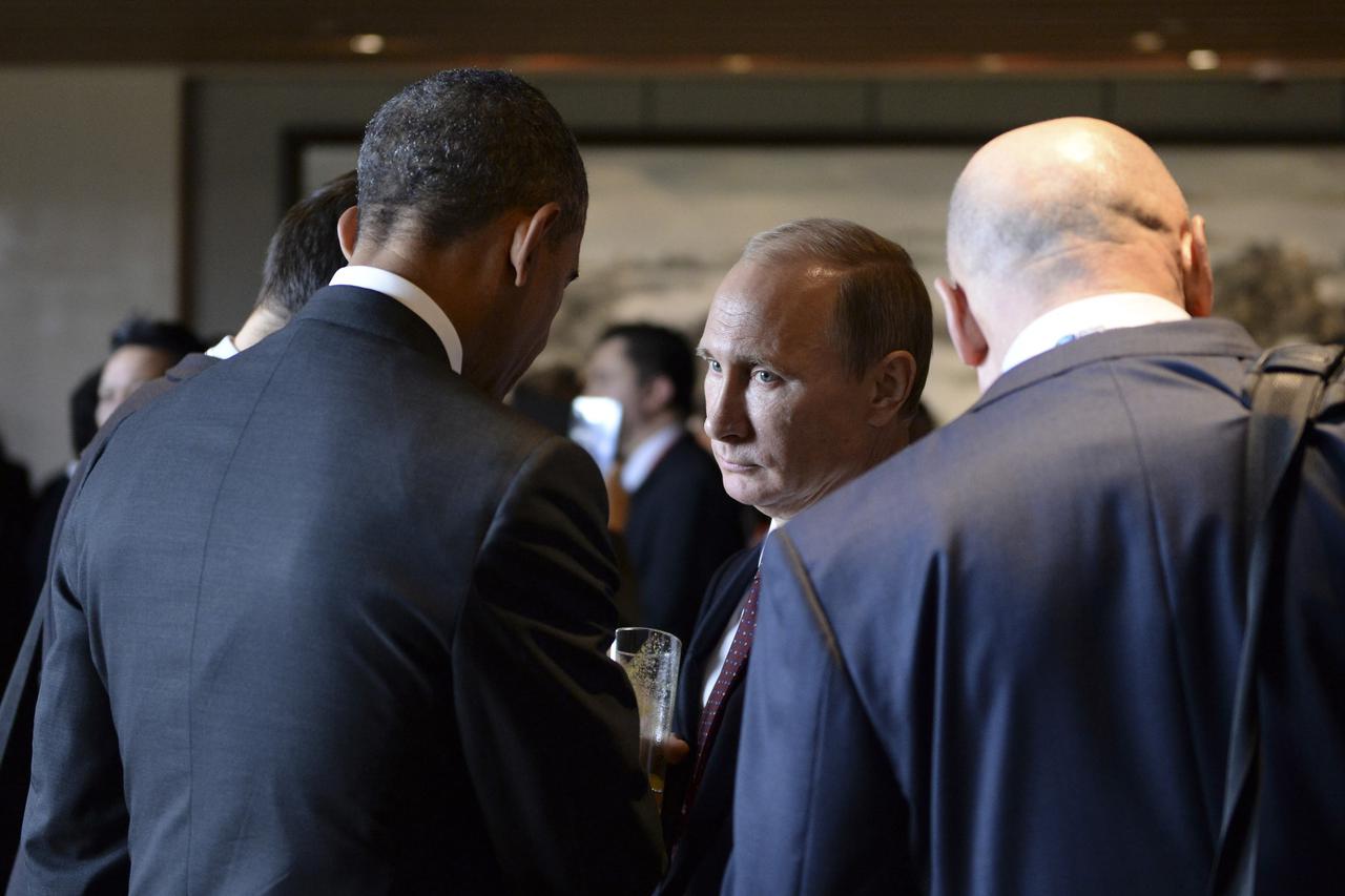 U.S. President Barack Obama (L) talks to his Russian counterpart Vladimir Putin (C) during the Asia Pacific Economic Cooperation (APEC) Summit in Beijing, November 11, 2014. REUTERS/Press service of the president of the Russian Federation/RIA Novosti (CHI