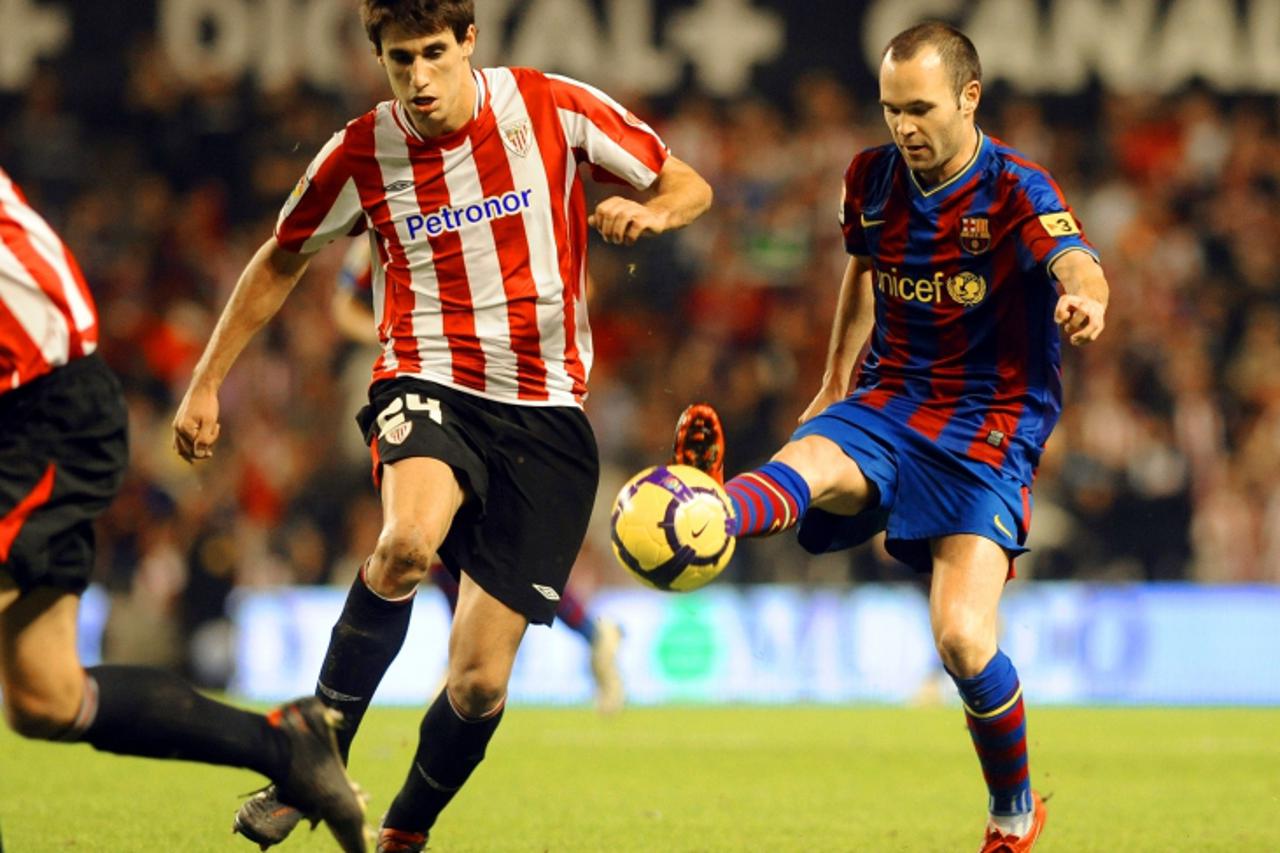 \'Athletic Bilbao\'s Javi Martinez (L) vies with Barcelona\'s Andres Iniesta (R) during a Spanish league football match, on November 21, 2009, at San Mames stadium in Bilbao. AFP PHOTO/Rafa Rivas\'