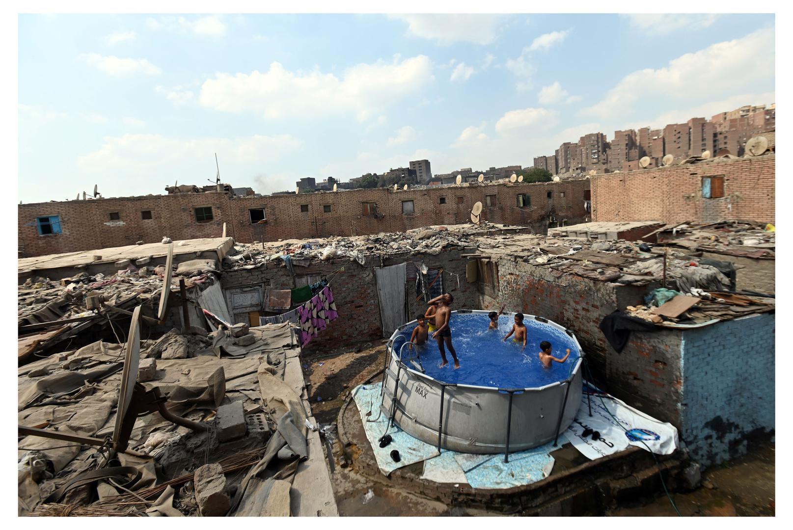 U El-Duweiqiju djeca se štite od vrućine igrajući se u malom bazenu među kućama, gdje voda postaje privremeno utočište