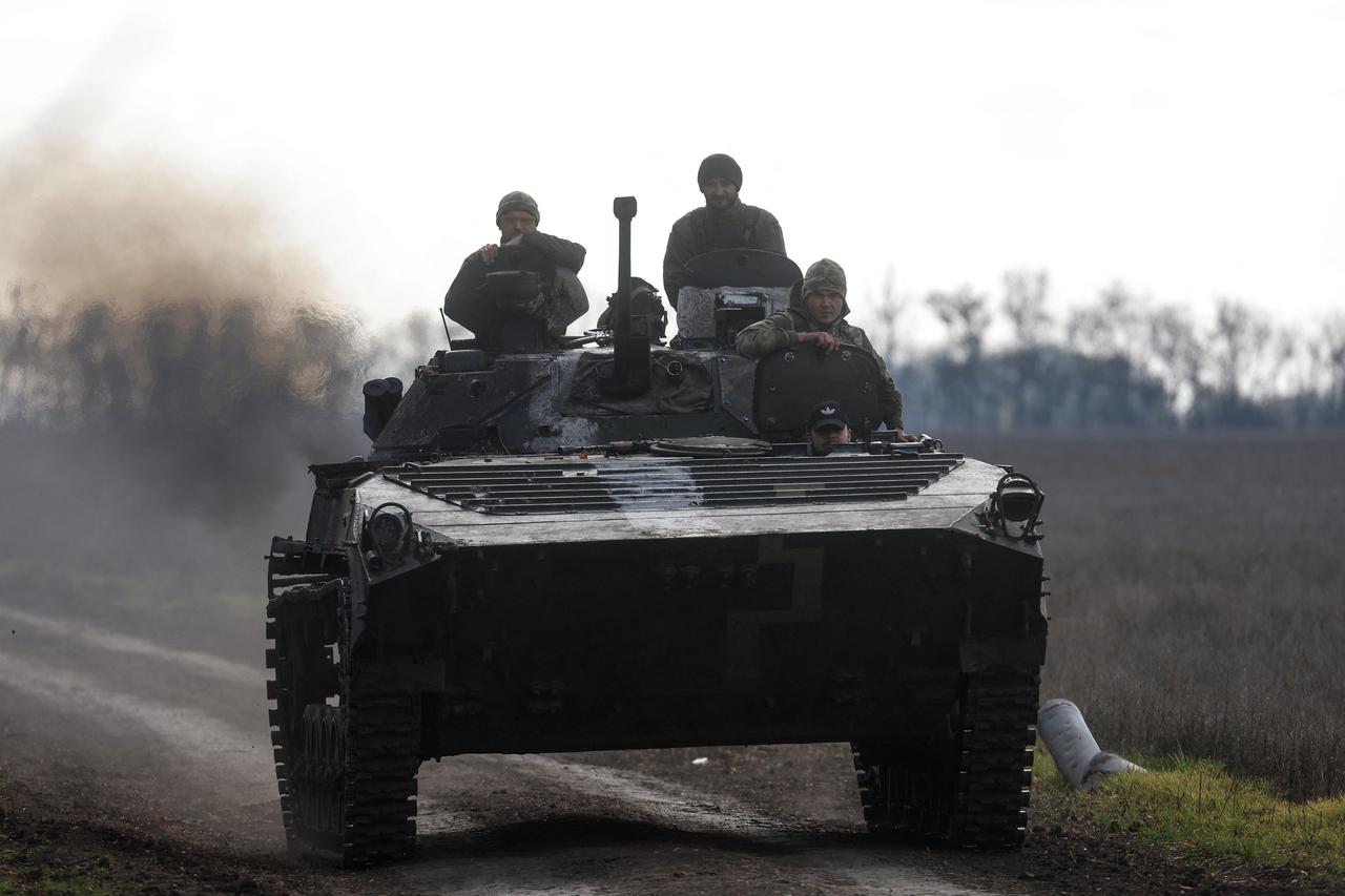 Ukrainian servicemen ride an armoured fighting vehicle in a frontline in Mykolaiv region